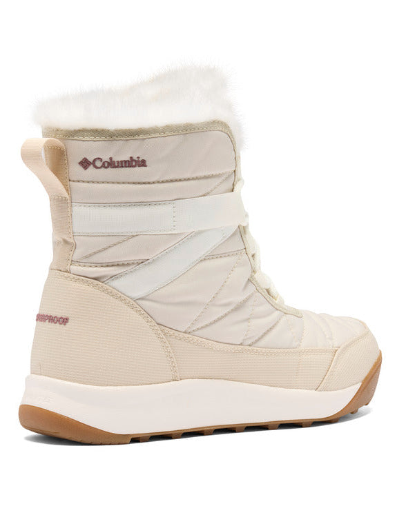 מגף חורף מדגם Minx Shorty IV של ColumbiaIL בצבע בז', עם צווארון מפרווה סינתטית לבנה, תפרים מרופדים וסוליה עבה מגומי בצבע לבן-חום, כפי שנראה מהצד. כולל הגנה מפני מים ולוגו של ColumbiaIL.